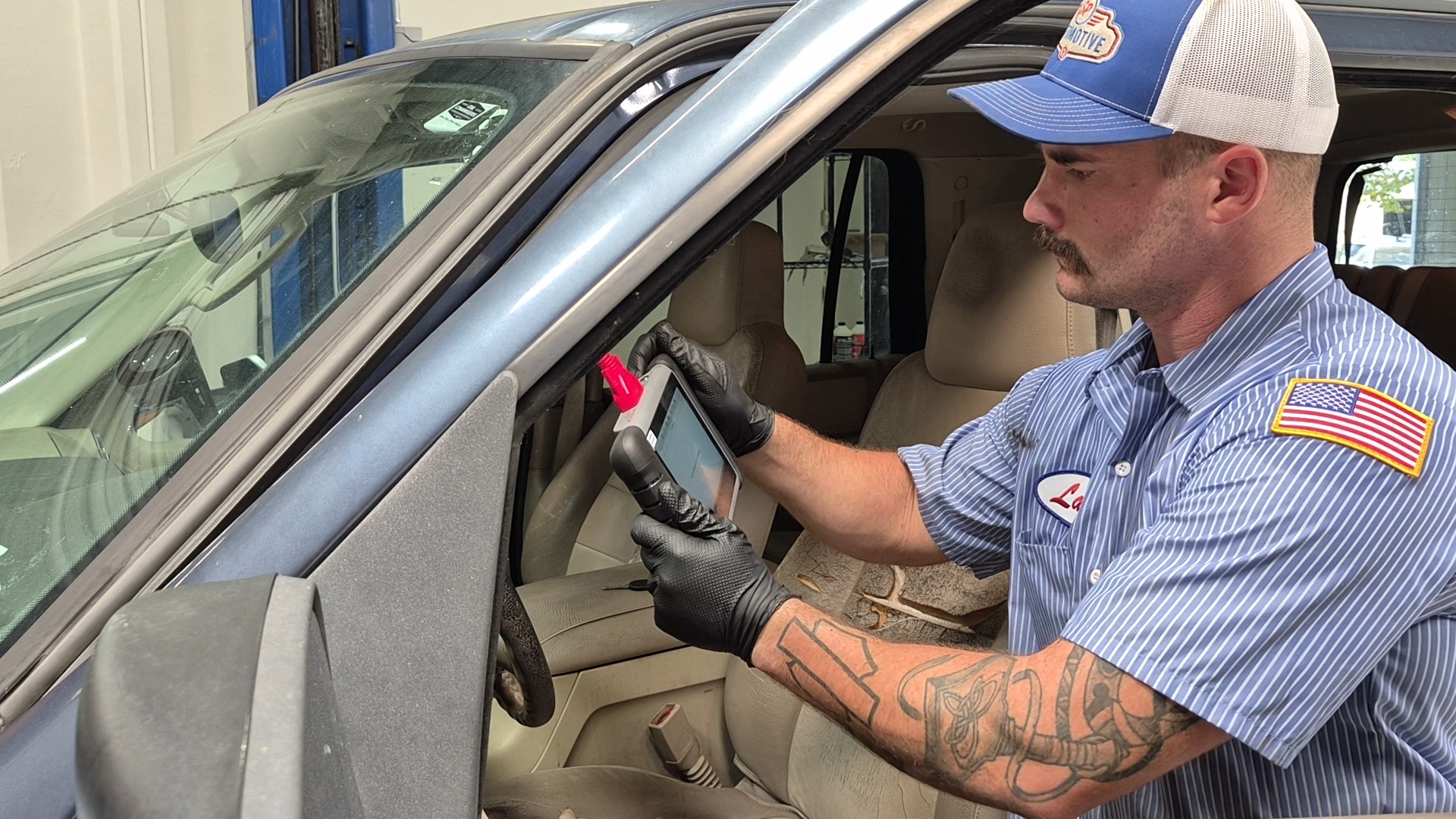 SP Automotive technician diagnosing a vehicle with a tablet